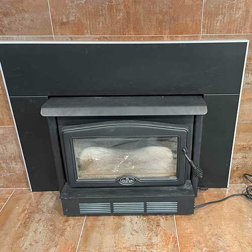 Stock photo of Fireplace - Black electric insert with large limestone slab surround.
